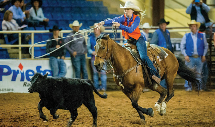 A female rodeo athlete competes in an event