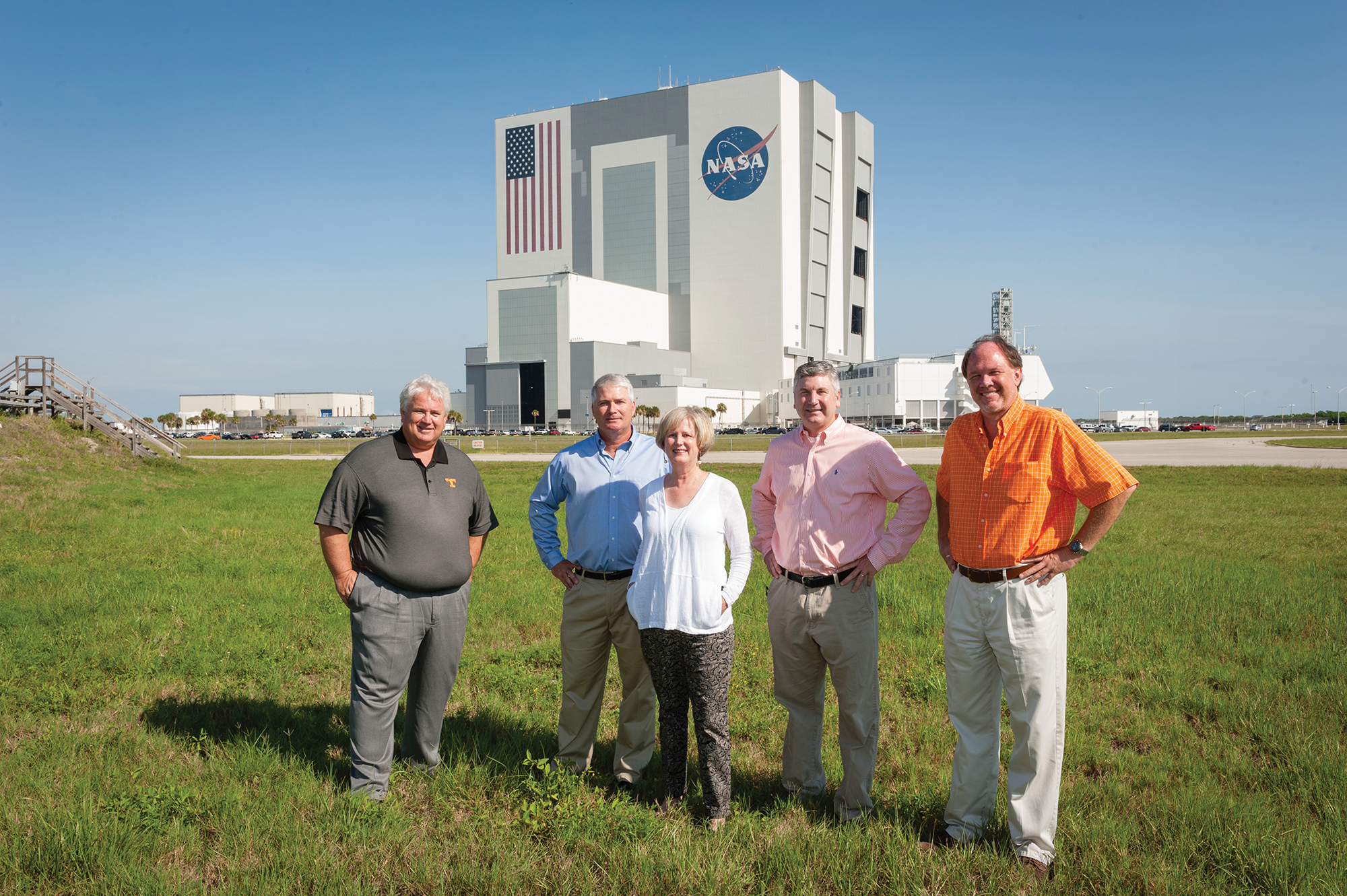 Group of five alumni stand in front of Kennedy Space Center