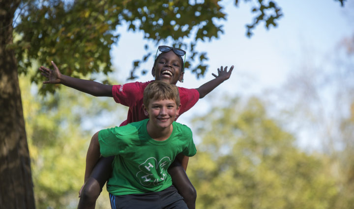 A 4-H camper gives another camper a piggy-back ride at the new Lone Oaks Farm 4-H Center