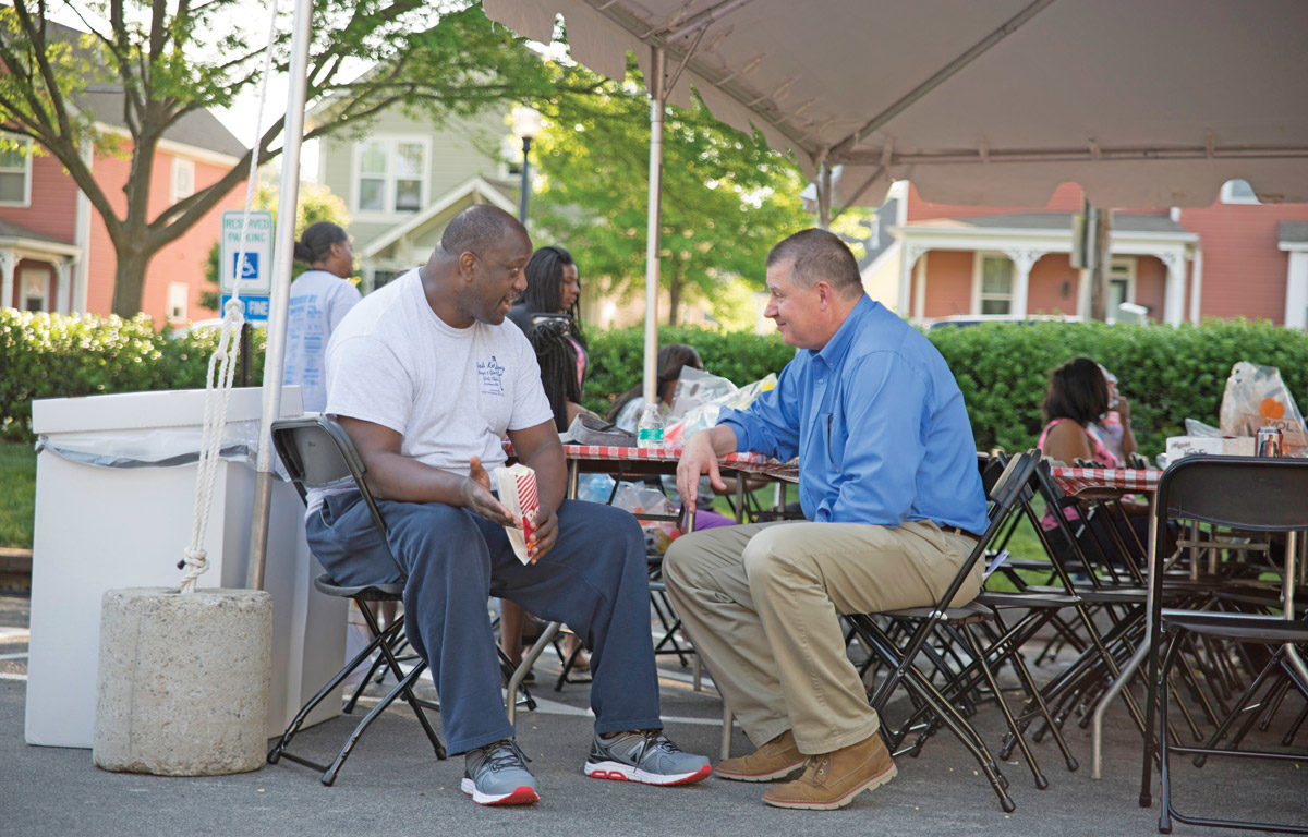 IPS Vice President Herb Byrd, right, visits with a neighbor at IPS block party.