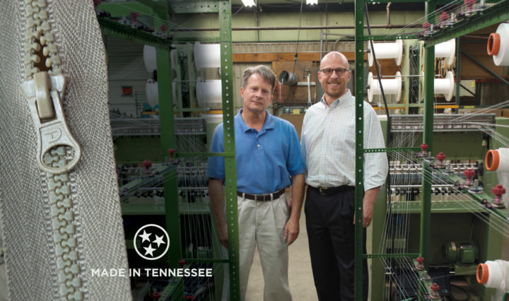Mike Kwasnik Jr. and Robert Kwasnik surrounded by zipper manufacturing equipment
