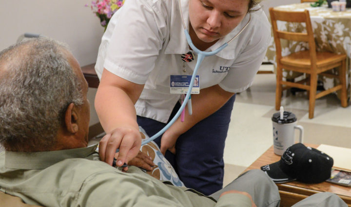 A female UTC nursing student listens to an older man's heartbeat