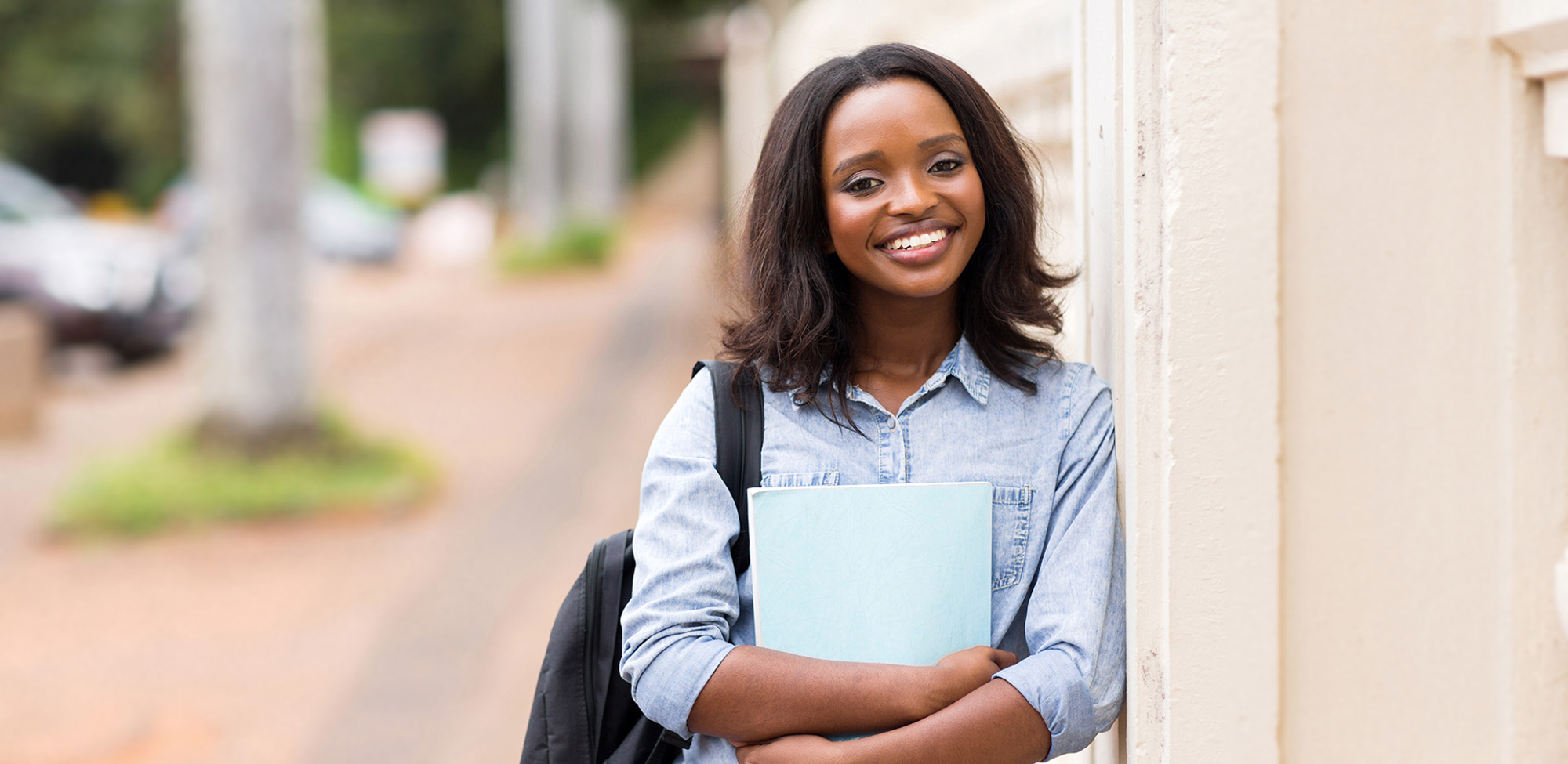 smiling african american young woman holding a book