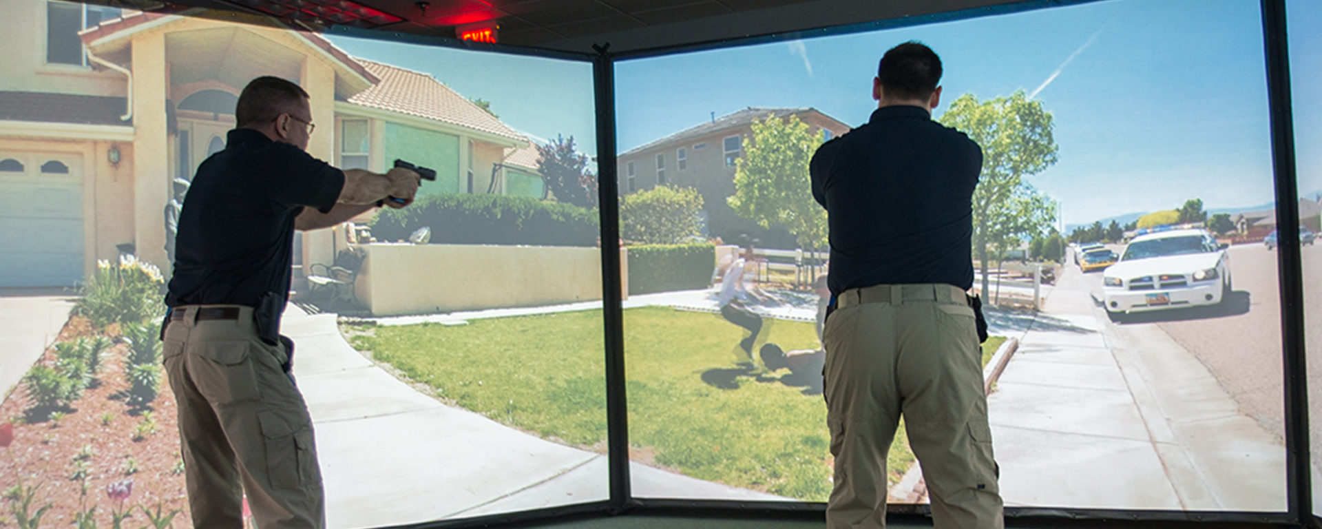 Training Specialist Chris Jones, left, and Training Coordinator Greg Coker participate in a firearm simulation at the LEIC in March.