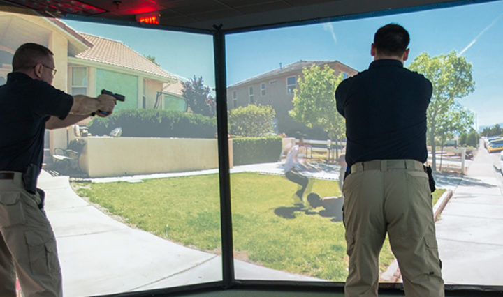 Training Specialist Chris Jones, left, and Training Coordinator Greg Coker participate in a firearm simulation at the LEIC in March.