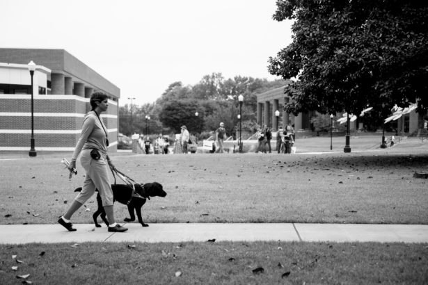 Ashley Jackson walks across the UT Martin campus with her black service dog, Mr. Bunkers