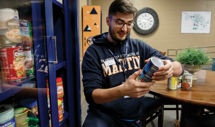 A UT Martin student volunteer sorts canned goods in the food pantry