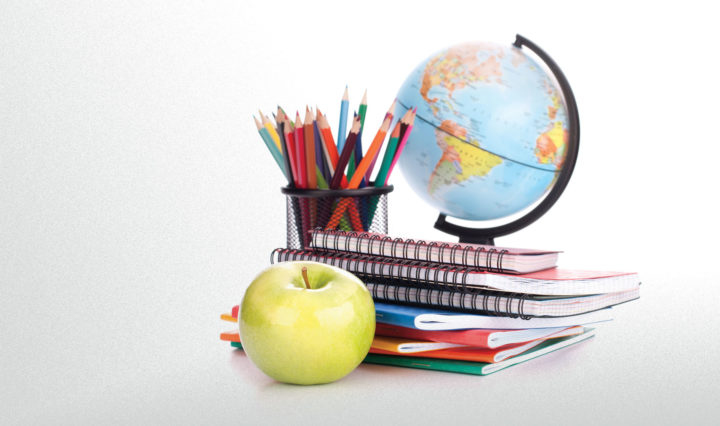teacher materials, colored pencils, golden delicious apple and a globe