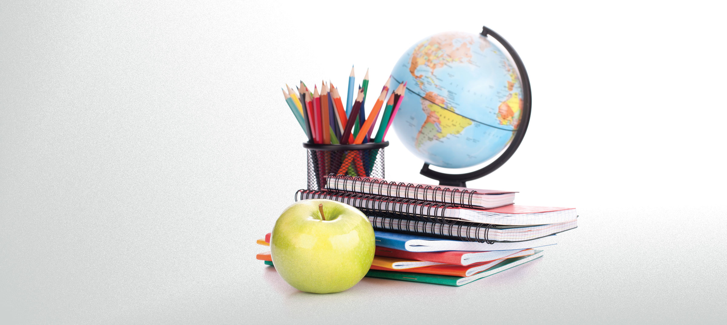 teacher materials, colored pencils, golden delicious apple and a globe