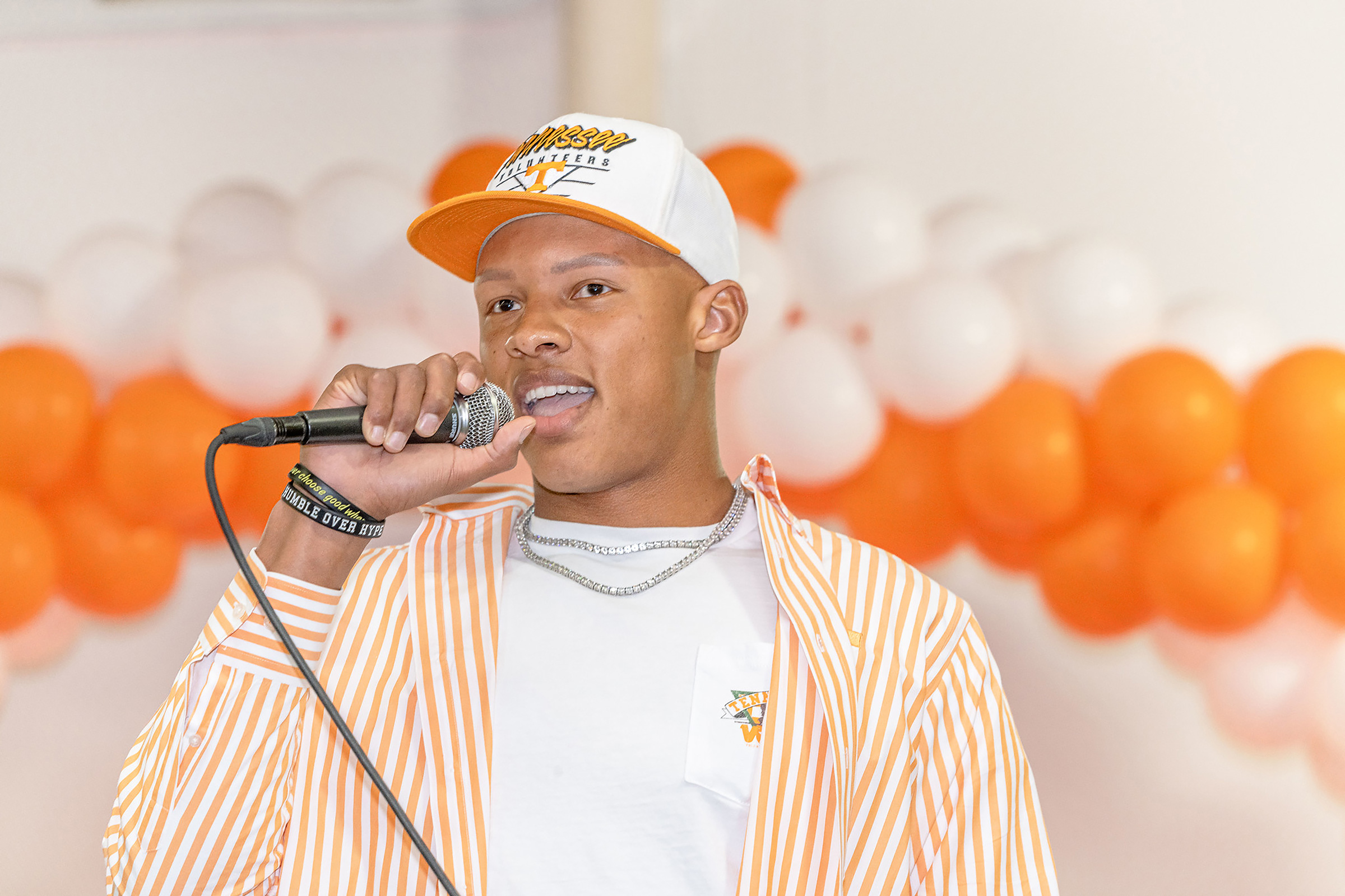 Joshua Dobbs, clad in orange and white speaks into a microphone