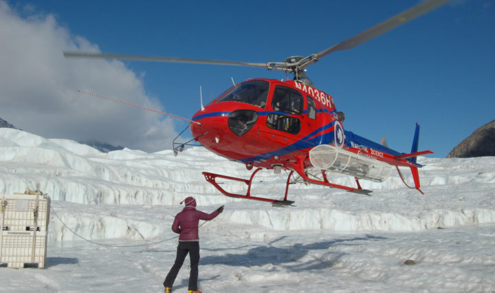 Jill Mikucki, associate professor of microbiology, meets a helicopter at her research site in Antarctica.
