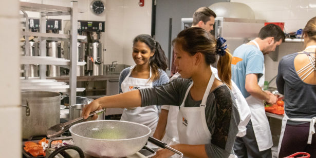 Kristina Lim and Mounica Konjeti prepare food in a professional kitchen
