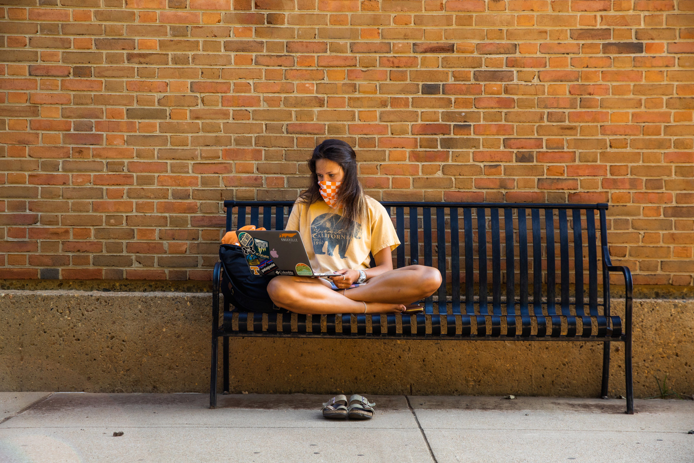 A young woman studies on a bench in the UT Humanities Plaza