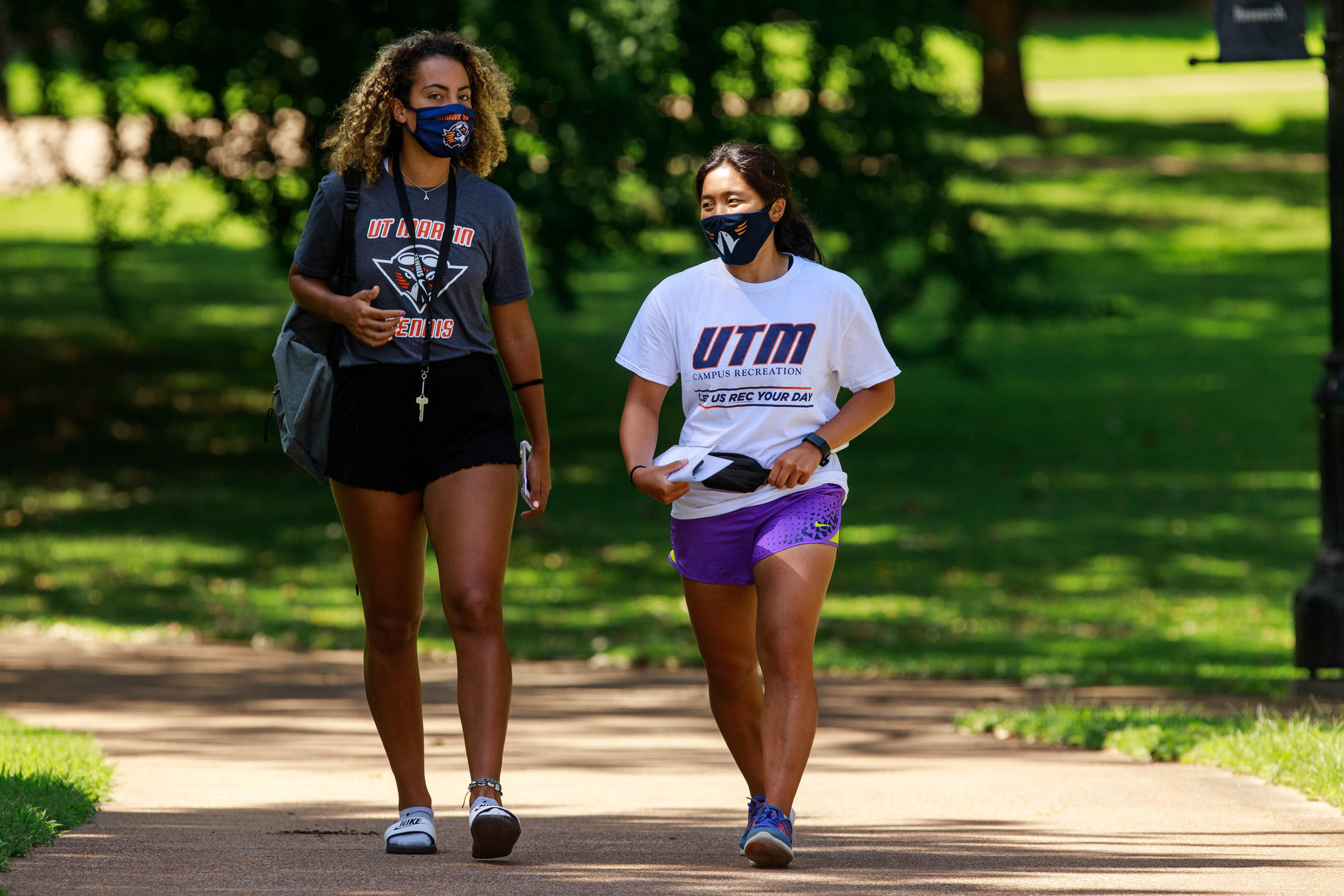 Two women walk on the UTM Quad to their class