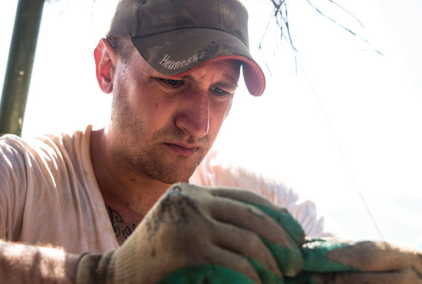 Kyle McCormick examines material evidence in Laos