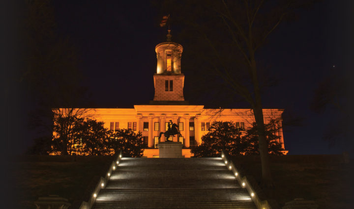 The Tennessee state capitol at night illuminated in orange light