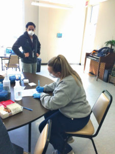 A nursing student volunteer completes vaccine paperwork