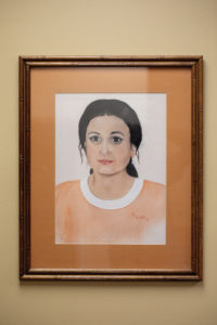 A framed watercolor portrait of an Indian woman dressed in orange