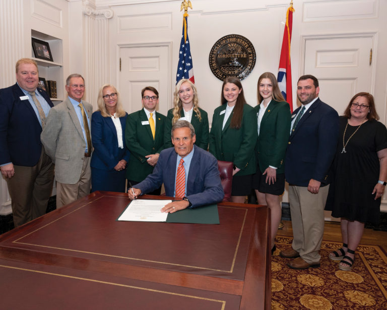 Governor Bill Lee signs a new law surrounded by 4-H participants and personnel