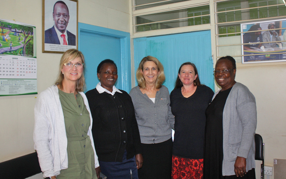 Five nurses pose for a photo in a classroom in Kenya