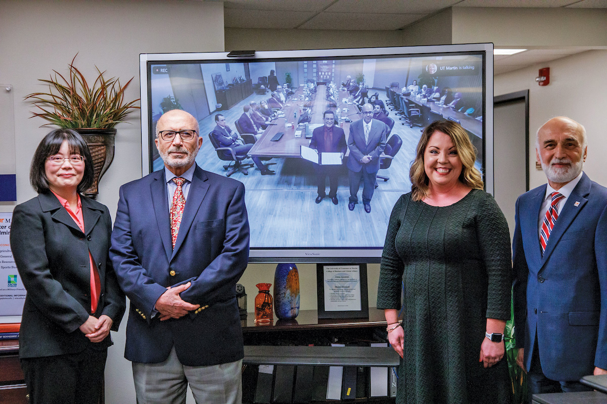 UT Martin's MBA leaders pose in front of a virtual screen with leaders from Nile University