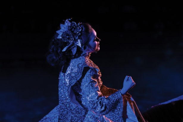 A woman in a princess dress in dramatic violet lighting