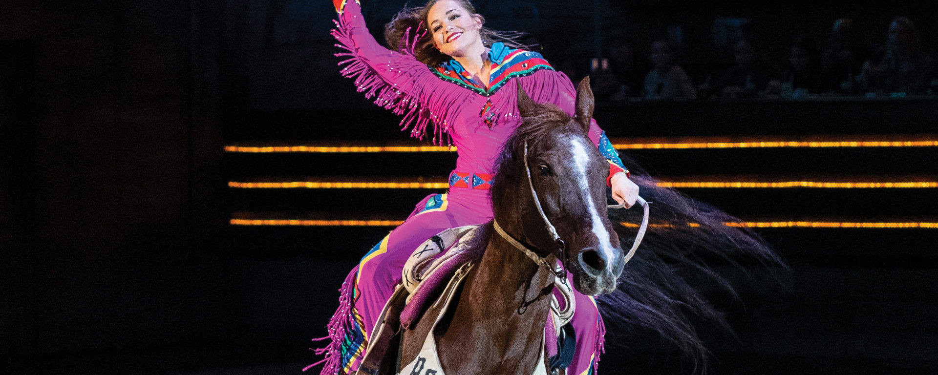Emma Jo Eversole greets the crowd on horseback at Dolly Parton's Stampede