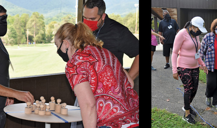 participants in masks and blindfolds assist each other in completing tasks in a leadership training activity
