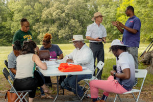 Under the shade tree, Frayser residents discuss this year's garden. 