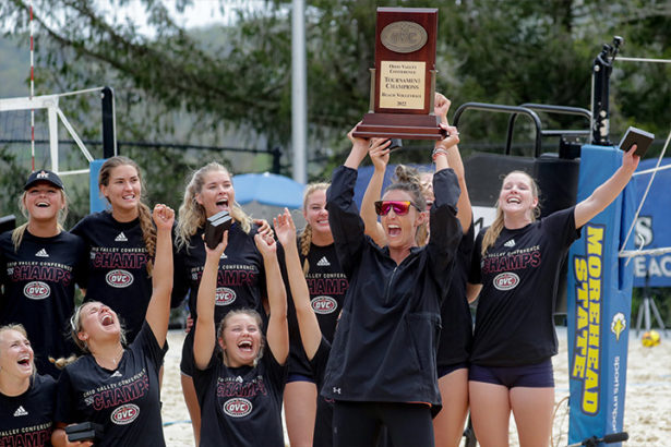 Head Coach Jaclynn Wilson hoists the championship trophy following the Skyhawks’ first beach volleyball tournament championship. 