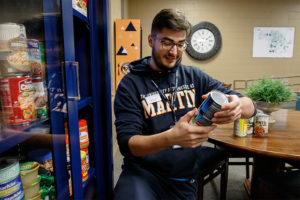 Jack Scalzo, of Murfreesboro, a resident assistant in Cooper Hall, adds canned food to one of UT Martin's food pantry locations. 