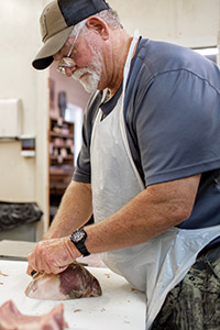 An employee at Benton's slices hams for packaging.