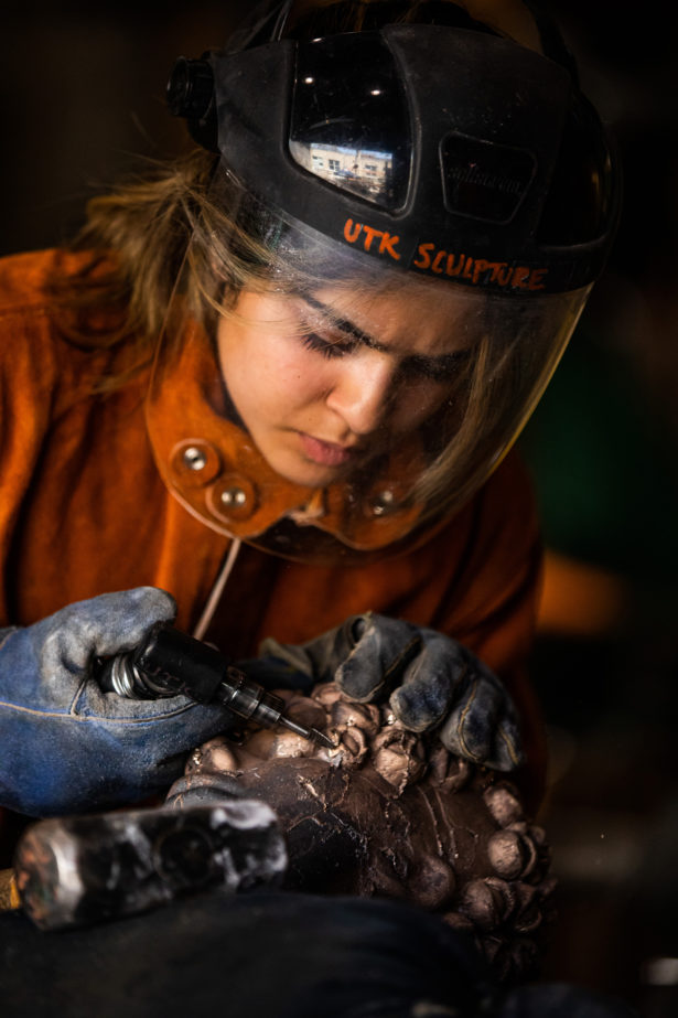 A UT Knoxville student cleans up her metal sculpture while working in the School of Art. Photo by Steven Bridges