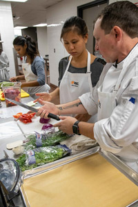 A chef demonstrates the correct way to hold a knife during a culinary medicine class. 