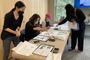  Japanese language students practice writing characters in calligraphy