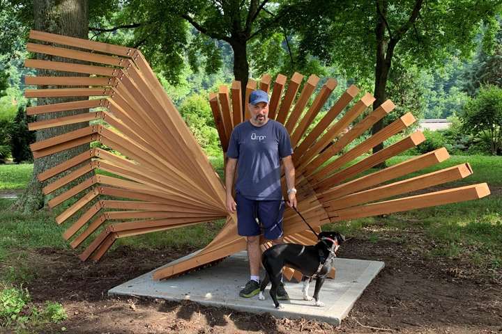 Artist Matt Baral with his dog and sculpture Two Arcs.