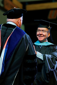 UT Martin Chancellor Keith Carver presents Dan Pigg with his seventh master’s degree. 