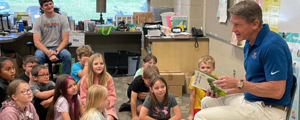 UT President Randy Boyd reads You Can't Buy a Dinosaur with a Dime to children during a Money Week class about financial literacy. Photo By Sam Thomas