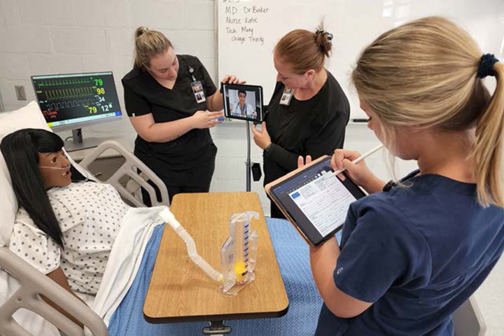 UT Southern nursing students practice on a simulator.