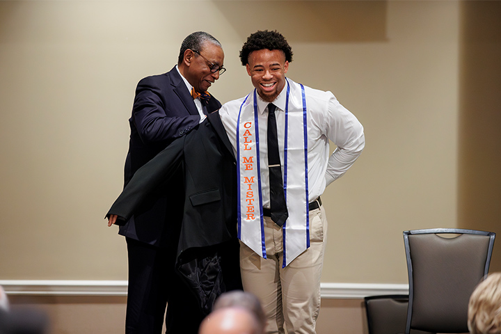 Jonathan Utley, a health and human performance K-12 major, receives a blazer from Samuel Tharpe, Call Me MiSTER coordinator of community outreach and advancement.