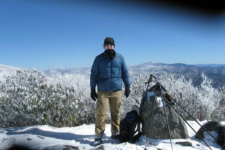 Aaron Boles stands atop a snow covered Rocky Top in winter clothing.
