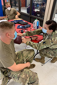 Ashtynn Barrett checks a fellow soldier's blood pressure.