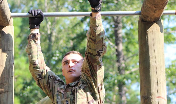 Daniel McPartland crosses the monkey bars on a ROTC obstacle course.