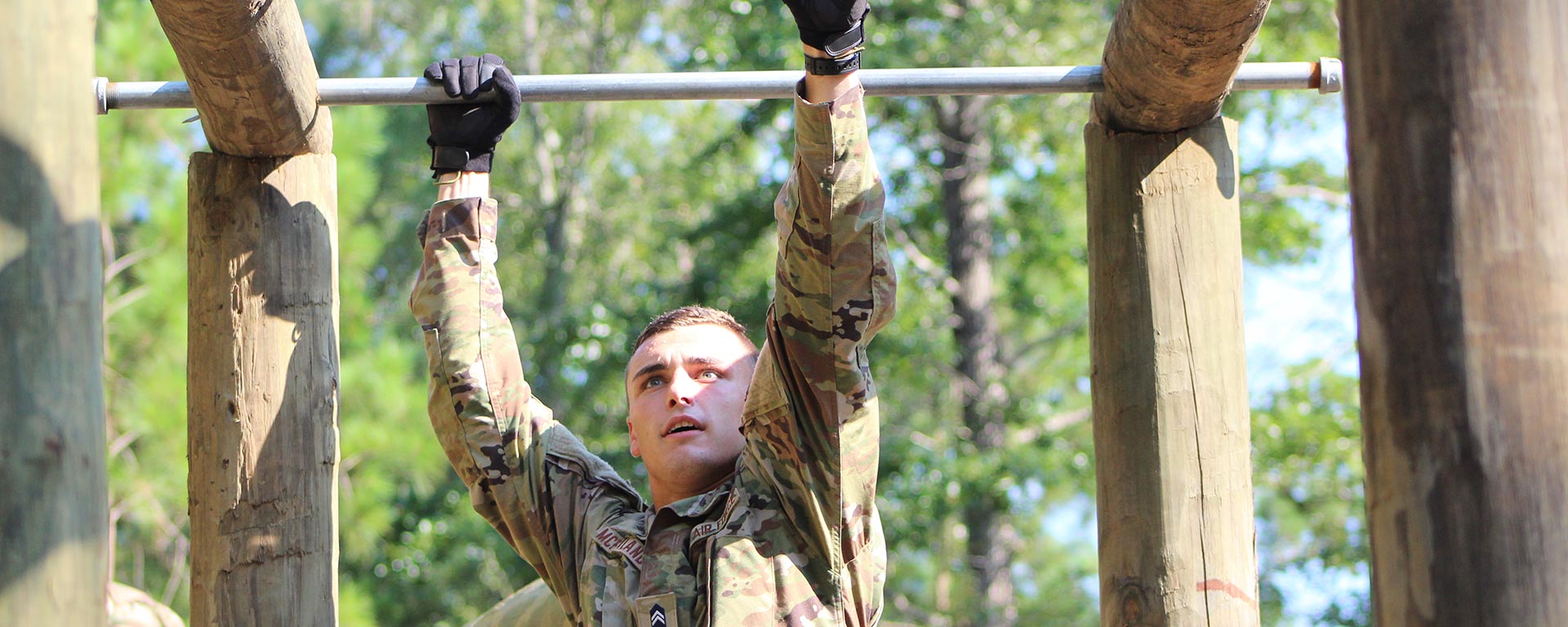 Daniel McPartland crosses the monkey bars on a ROTC obstacle course.