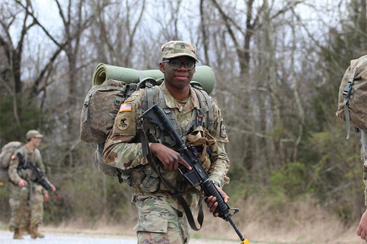 Mark Hancock holds his weapon at the low ready during a road march for ROTC training.