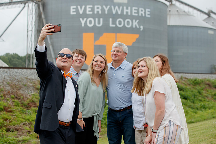 UTIA Senior Vice Chancellor and Senior Vice President Keith Carver snaps a selfie with Keith Fowler and family in front of their mural in Weakley County.