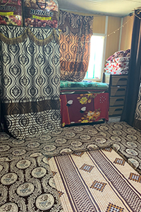 Refugee homes using hung carpets and mats as room separators.