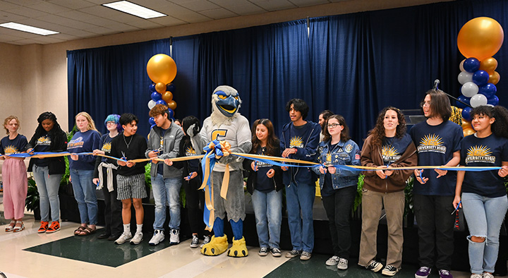 University High students, along with Scrappy Moc, cut the ribbon to kick off the new high school in April 2023.