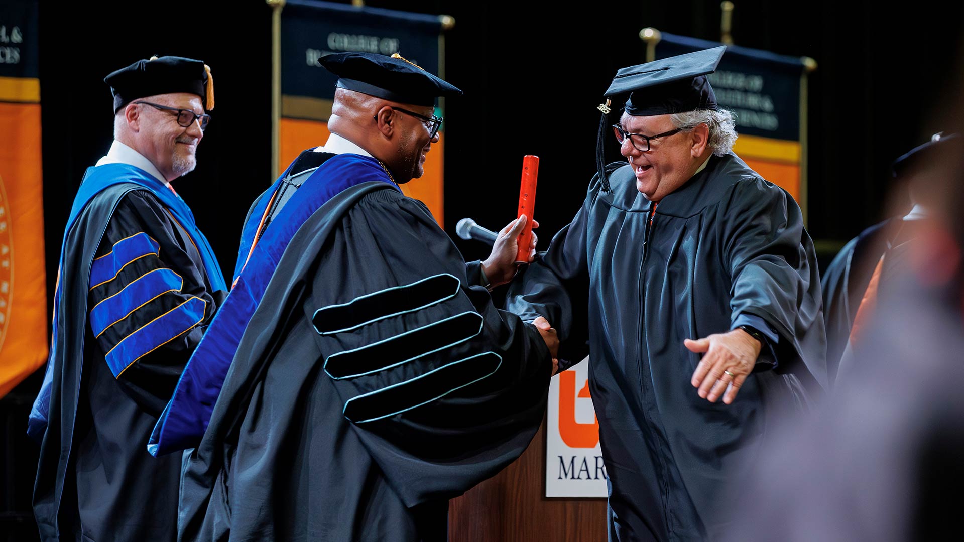 Yancy Freeman congratulates Hal Bynum on earning his UT Martin degree during Freeman’s first commencement as chancellor. Looking on is Philip Acree Cavalier, provost and senior vice chancellor for academic affairs.