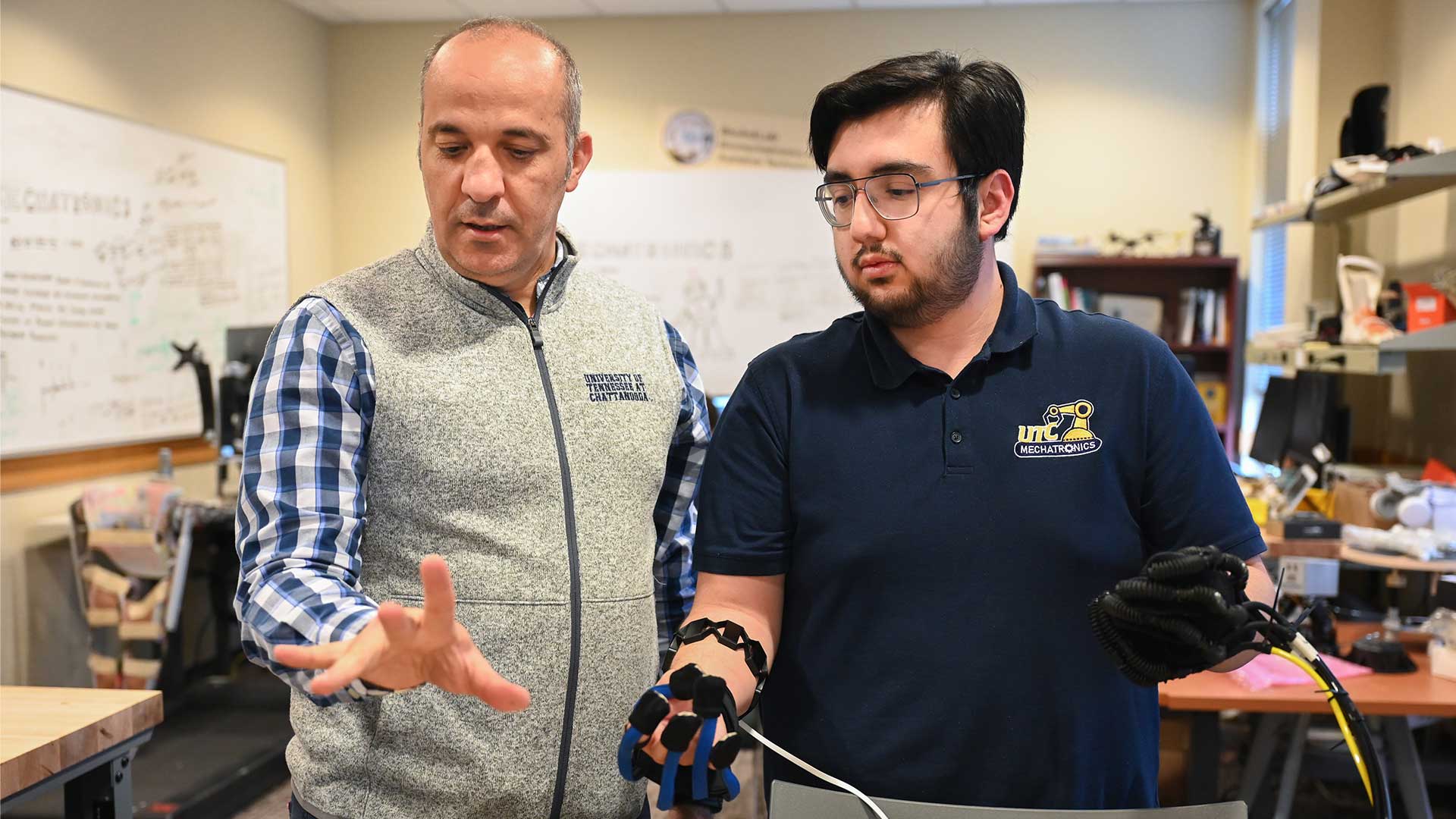 Erkan Kaplanoglu, left, and Juan Pena work on the hand rehabilitation system.